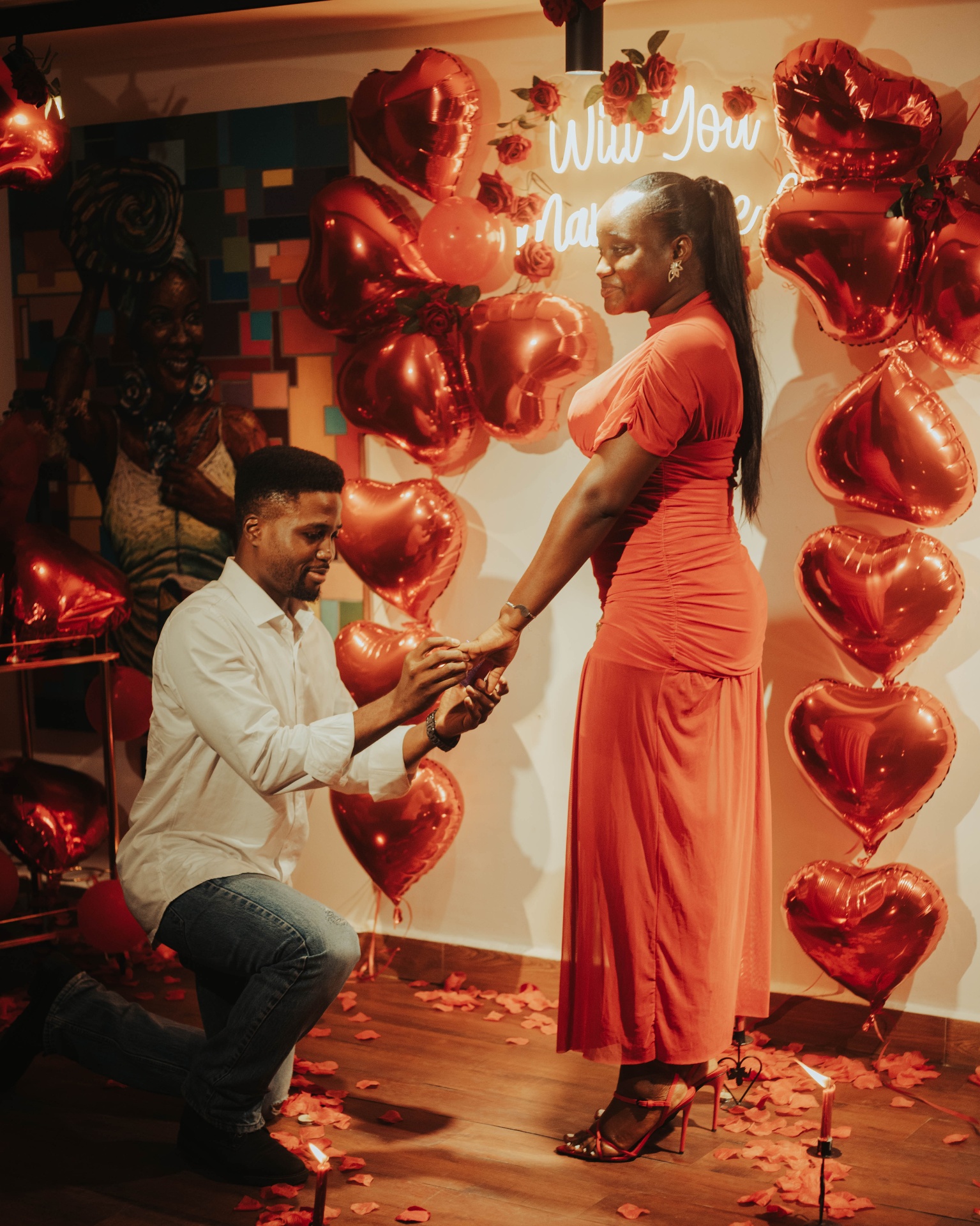 Kofo and Fiye sharing a long embrace beneath the proposal sign